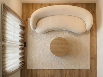 The same living room seen straight down, with the sofa, rug and table read as a plan