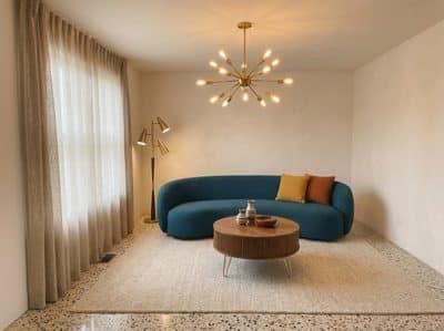 The same room with a teal curved sofa, a brass sputnik chandelier and a terrazzo floor